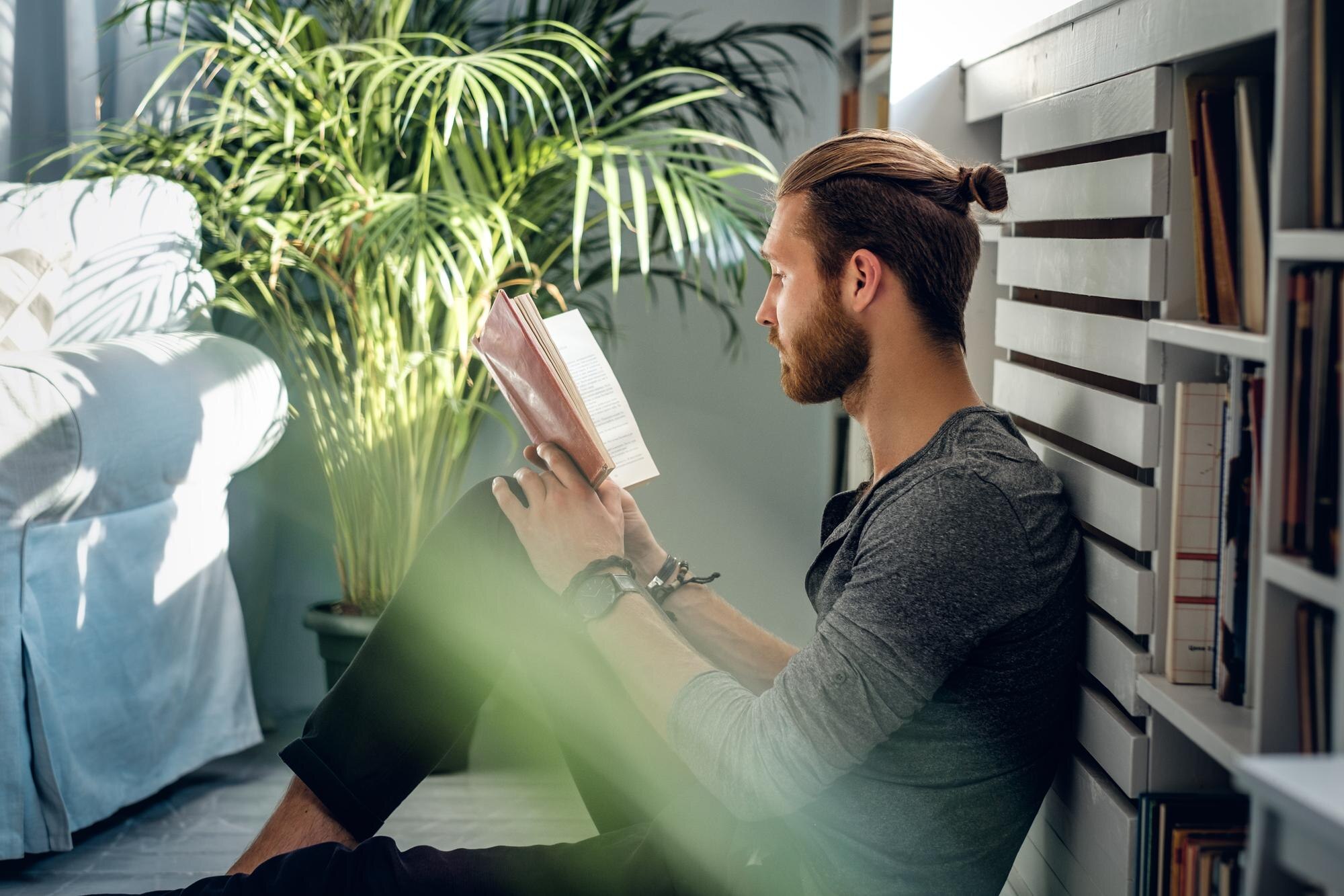 Persona leyendo un libro junto a una ventana
